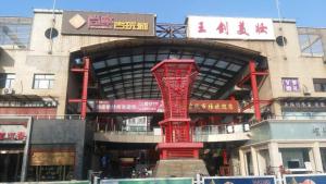 uma estrutura vermelha em frente a um edifício em 7Days Premium Tangshan Xinhua Road University of science and engineering em Tangshan