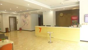 a lobby with a reception desk and a clock on the wall at 7Days Premium Tangshan Xinhua Road University of science and engineering in Tangshan