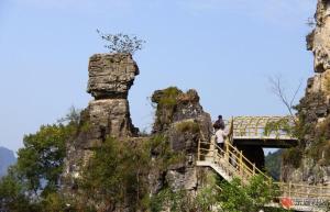 a bridge on a mountain with two people on it at 7Days Inn Changyang Qingjiang Yichang Gallery in Yichang
