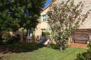 a tree with purple flowers in the yard of a house at Gîte du Pagoulin - Gîte in Hyères