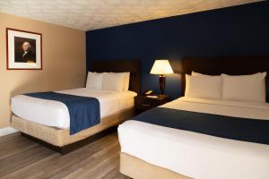 a hotel room with two beds and a lamp at Hotel Pentagon in Arlington