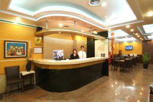 two people standing at a bar in a restaurant at Golden Swallow Hotel in Hsinchu City