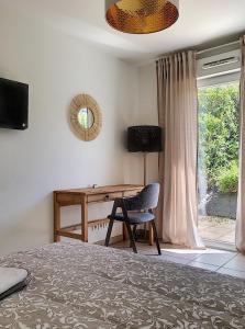 a bedroom with a desk and a chair and a bed at Studio en face Hopital Nord avec terrasse in Saint-Priest-en-Jarez