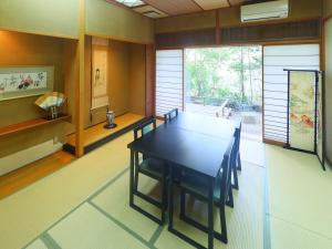 a dining room with a black table and chairs at Kinugawa Onsen Hana no Yado Matsuya in Nikko