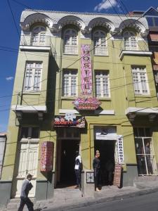 un edificio amarillo con gente caminando delante de él en No Fear Hostel, en La Paz