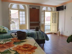 a bedroom with a bed and two windows and a table at No Fear Adventure Hostel in La Paz