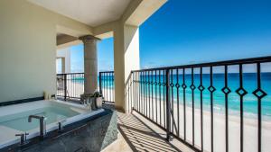 Grand Park Royal Cancun - All Inclusive في كانكون: حوض استحمام على شرفة مطلة على المحيط