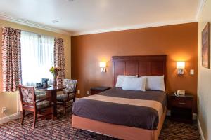 um quarto de hotel com uma cama, uma secretária e uma mesa em Seaside Inn Monterey em Seaside