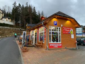 ein kleines Holzgebäude an der Straßenseite in der Unterkunft Łomniczanka in Karpacz