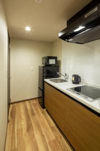 a kitchen with a sink and a refrigerator at Hotel Imari Aioibashi Bettei in Imari