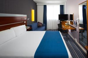 a hotel room with a bed, desk and a television at Holiday Inn Express London-Wimbledon-South, an IHG Hotel in London