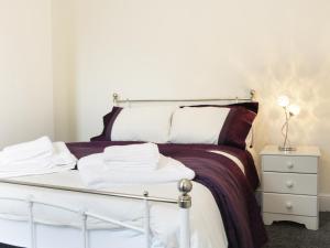 ein Schlafzimmer mit einem Bett und einem Nachttisch mit Handtüchern in der Unterkunft 7 Monkmoor Road in Shrewsbury