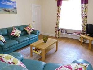 a living room with a blue couch and a coffee table at Sky Blue Cottage in Forth