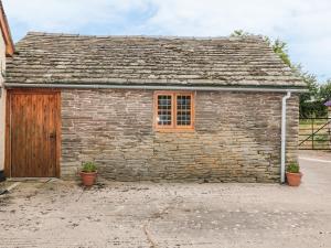 an old stone building with a wooden door at The Cow Cott in Peterchurch