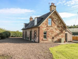 an old brick house on a gravel driveway at Bonjedward Mill Farm Cottage in Jedburgh