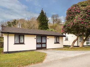 ein weißes Haus mit einem Baum davor in der Unterkunft Chy Lowenna in Saint Cleer