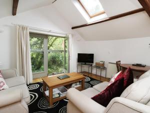 uma sala de estar com dois sofás e uma mesa em Holemire Barn em Cockermouth