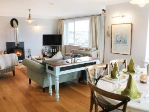 a living room with a table and a piano at Cable House in Cemaes Bay