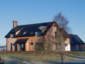 a large wooden house sitting on top of a field at Sobrachan in Braevallich