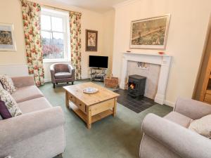 a living room with a fireplace and a table at 27-29 St Marys Place in Kirkcudbright