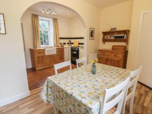 a dining room with a table and a kitchen at 27-29 St Marys Place in Kirkcudbright