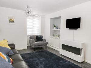 a living room with a couch and a tv at 11 Camden Building in Kendal