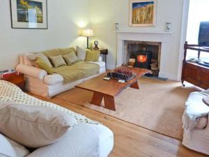 a living room with a couch and a fireplace at Easter Urray Farmhouse in Muir of Ord