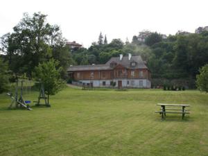 a large field with a house and a picnic table at Dworek Karpińskich in Sandomierz