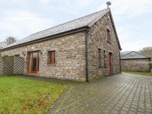 um antigo edifício de pedra com uma entrada de tijolos em Longside em Abergavenny