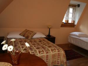 een slaapkamer met een bed en een vaas met bloemen op een tafel bij Dworek Karpińskich in Sandomierz