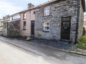una vieja casa de piedra al lado de una calle en 19 Cwmorthin Road, en Blaenau Ffestiniog
