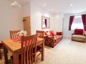 una sala de estar con una mesa y un sofá en 19 Cwmorthin Road, en Blaenau Ffestiniog 6 fotos más