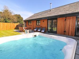 a large hot tub in the backyard of a house at Pig House, Boskensoe Barns in Helford Passage