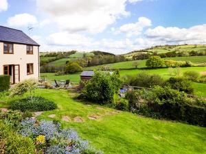 a house in the middle of a green field at Glebe Farm Cottage in Pontnewydd
