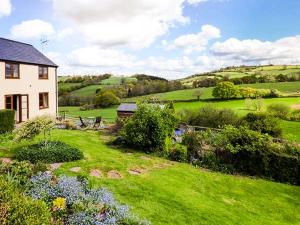 a house in the middle of a green field at Glebe Farm Cottage in Pontnewydd