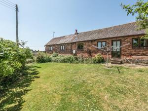 an old brick house with a yard in front of it at Garden Barn in Highley