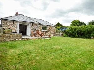 a stone house in a field with a green yard at Shepherds Rest in Warbstow