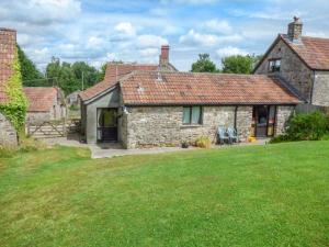 a stone house with a green lawn in front of it at The Old Parlour in Winford