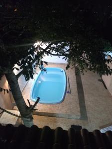 una vasca da bagno blu seduta accanto a un albero di Casa com piscina e churrasqueira a Iguaba Grande
