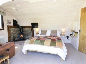 um quarto com uma cama grande e uma lareira em Idris Pod em Tremeirchion