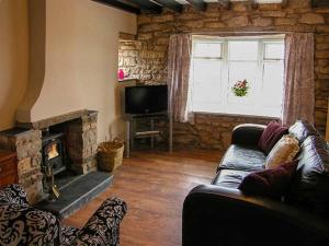 a living room with a couch and a fireplace at Ty Cerrig in Mold