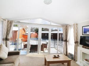 a living room with a couch and a tv at 32 Cruachan Lodge in Auchterarder