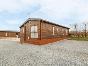 ein kleines Holzhaus auf einem Schotterplatz in der Unterkunft Avonal Lodge 24 in Perth