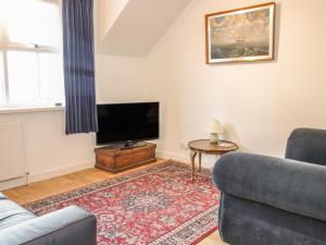 a living room with a couch and a tv at The Rest in Eyemouth