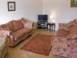 a living room with two couches and a flat screen tv at The Loft in Annan