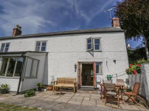 een wit huis met een tafel en stoelen bij The Cottage in Llangollen