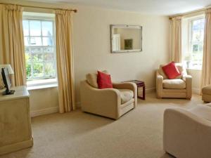 a living room with two chairs and a mirror at Kennels Cottage in Saint Boswells