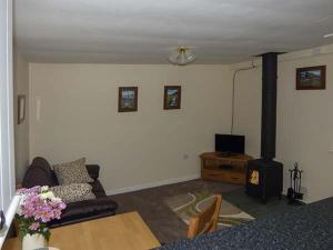 a living room with a couch and a wood stove at Cockley Beck Cottage in Coniston