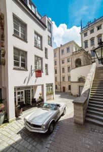 une voiture en argent garée devant un bâtiment dans l'établissement Hotel am Rathaus, à Augsbourg