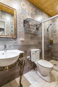 ein Badezimmer mit einem Waschbecken, einem WC und einem Spiegel in der Unterkunft Starry Home in Xiaoliuqiu